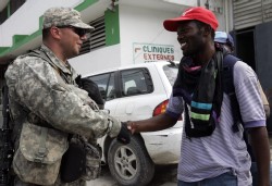 Un soldado saluda a un haitiano en Puerto Príncipe